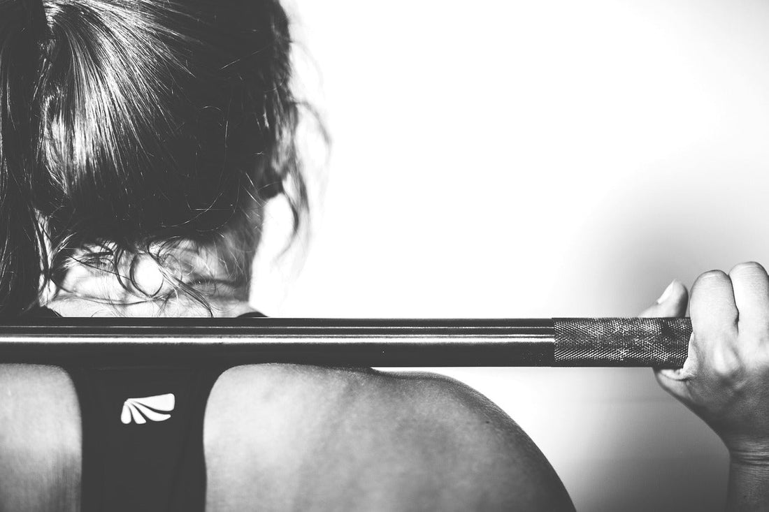 Woman lifting barbell showcasing strength and fitness for creatine supplements for women