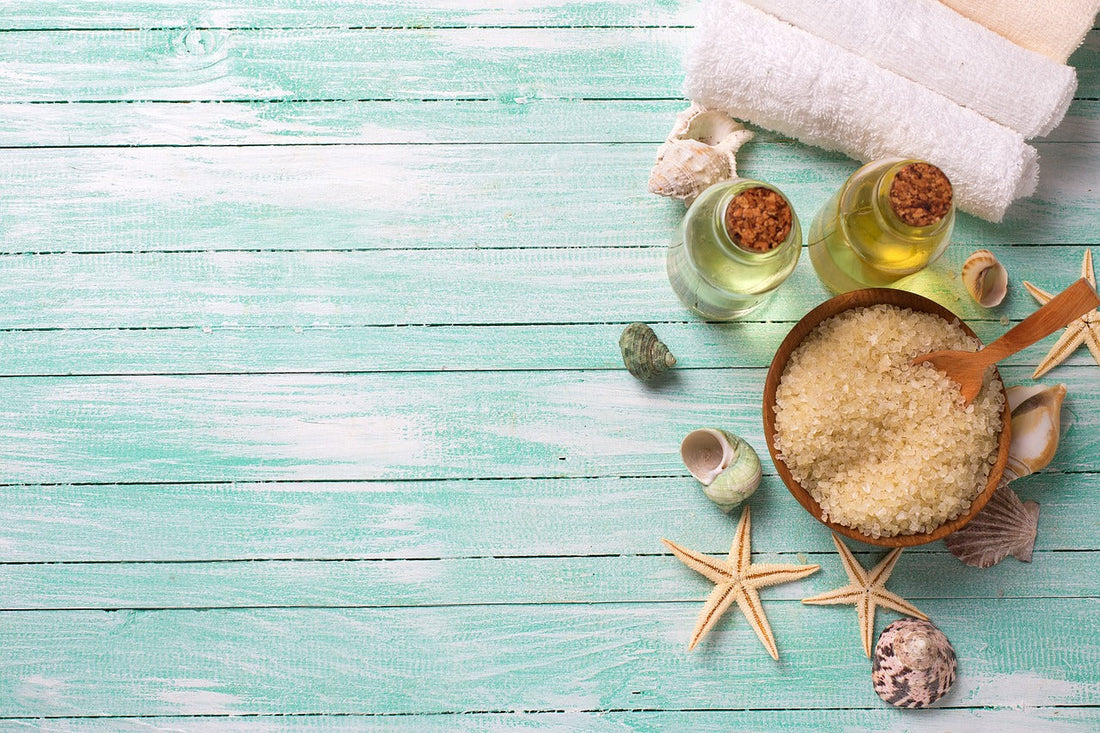 Natural skincare products and sea salt scrub on turquoise wooden background for sun-damaged skin repair