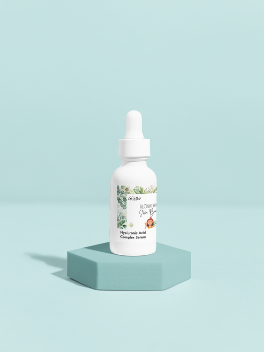 GLOWTHY+ SKIN BOOSTER Hyaluronic Acid Complex Serum in white glass bottle with dropper on blue pedestal.